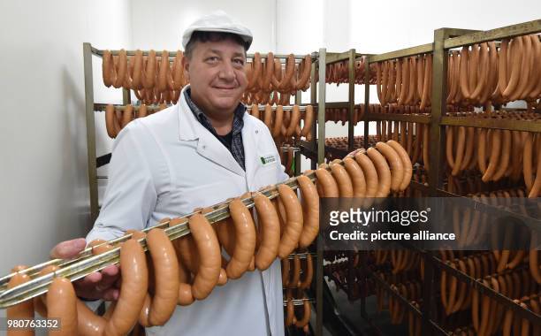 February 2018, Germany, Velten: Thomas Schubert, CEO of the organic manufactory Havelland, carries fresh sausages. The company with 35 employees...