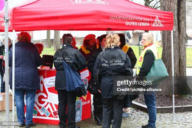Public service employees of Gera's city administration, gather around an information stand during a warning strike organised by service sector union...