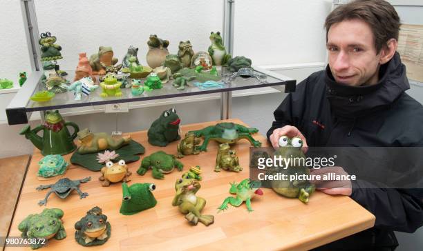 March 2018, Germany, Schierke: Marc Kinkeldey, weather service technician at the German Weather Service , shows a collection of weather frogs in a...