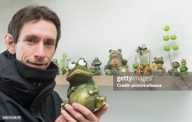 March 2018, Germany, Schierke: Marc Kinkeldey, weather service technician at the German Weather Service , shows a collection of weather frogs in a...