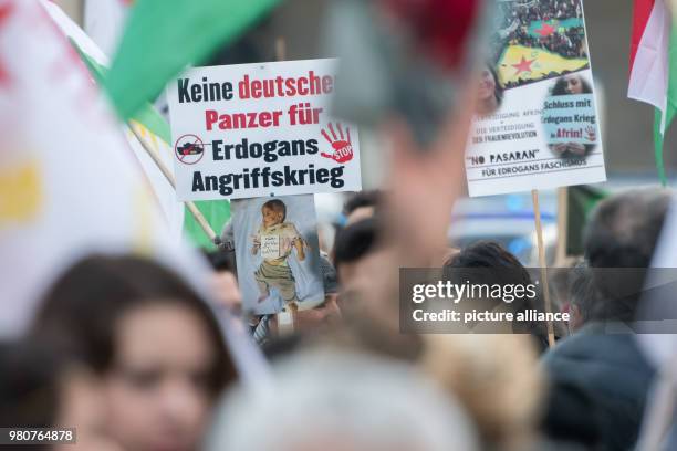 March 2018, Germany, Munich: Protestors holding up a poster with the inscription "no German tanks for Erdogan's war of aggression" in order to...