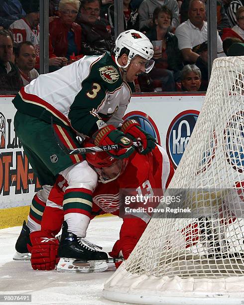 Marek Zidlicky of the Minnesota Wild gets tied up with Pavel Datsyuk of the Detroit Red Wings and he tries to get up off the ice during an NHL game...