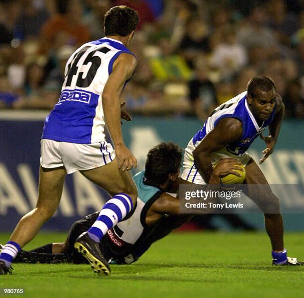 Che Cockatoo-Collins for Port Adelaide tackles Byron Pickett for the Kangaroos the Ansett Cup semi-final match between Port Power and the North...