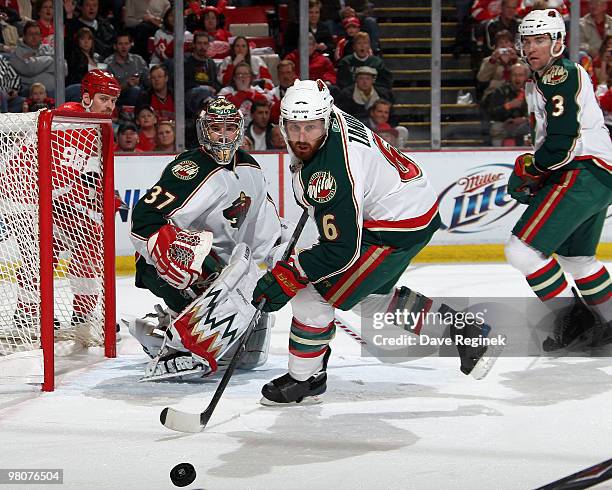 Josh Harding of the Minnesota Wild and teammates Greg Zanon, Marek Zidlicky along with Tomas Holmstrom of the Detroit Red Wings watch the loose puck...