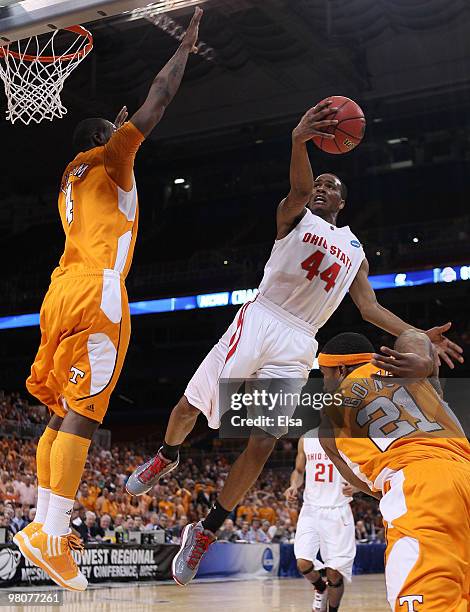 William Buford of the Ohio State Buckeyes goes up for a shot as Melvin Goins and Wayne Chism of the Tennessee Volunteers defend during the midwest...