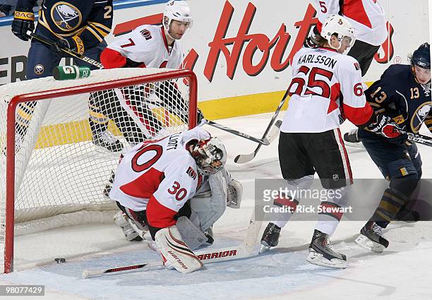 Tim Kennedy of the Buffalo Sabres watches his shot slide past Brian Elliott and Erik Karlsson of the Ottawa Senators and into the net for a goal at...