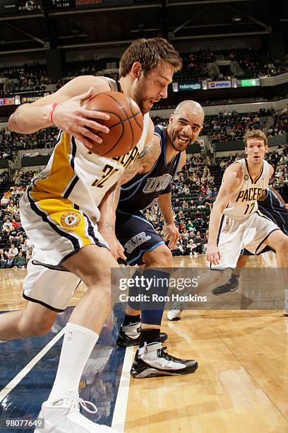 Josh McRoberts of the Indiana Pacers takes the ball from Carlos Boozer of the Utah Jazz at Conseco Fieldhouse on March 26, 2010 in Indianapolis,...