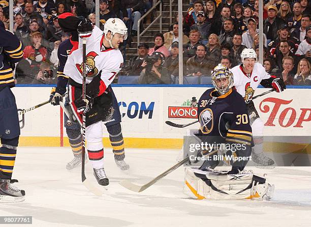 Ryan Miller of the Buffalo Sabres follows the puck as Nick Foligno of the Ottawa Senators jumps through the air on March 26, 2010 at HSBC Arena in...