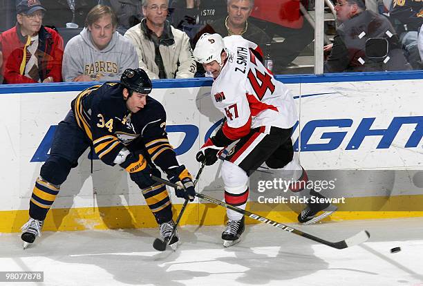 Chris Butler of the Buffalo Sabres flips the puck away from Zack Smith of the Ottawa Senators at HSBC Arena on March 26, 2010 in Buffalo, New York.