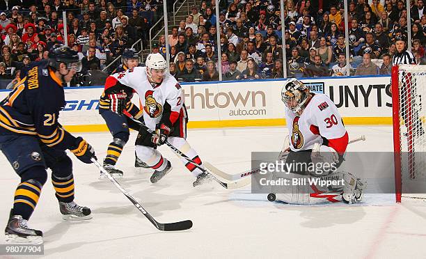 Drew Stafford of the Buffalo Sabres has his third period shot stopped by Anton Volchenkov and Brian Elliott of the Ottawa Senators on March 26, 2010...