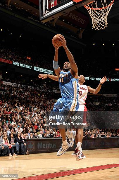 Nene of the Denver Nuggets double pumps and tries the layup ahead of DeMar DeRozan of the Toronto Raptors during a game on March 26, 2010 at the Air...