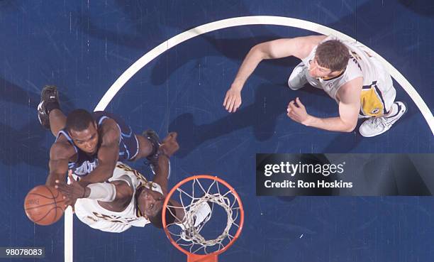 Paul Millsap of the Utah Jazz battles Roy Hibbert and Troy Murphy of the Indiana Pacers at Conseco Fieldhouse on March 26, 2010 in Indianapolis,...