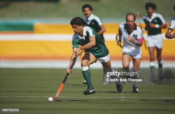 Pakistan field hockey player Mushtaq Ahmad makes a run with the ball during the pool B game between New Zealand and Pakistan in the Men's Field...