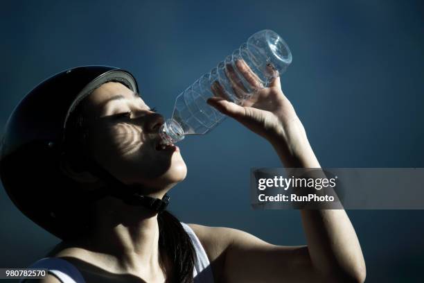 young woman drinking water from bottle on mt.fuji - newoutdoors stock pictures, royalty-free photos & images