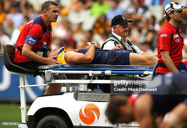 Brad Green of the Demons is taken from the ground after being hit head high during the round one AFL match between the Melbourne Demons and the...