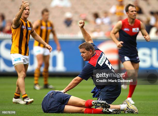 Trainer calls for assistance for Brad Green of the Demons after being hit head high during the round one AFL match between the Melbourne Demons and...