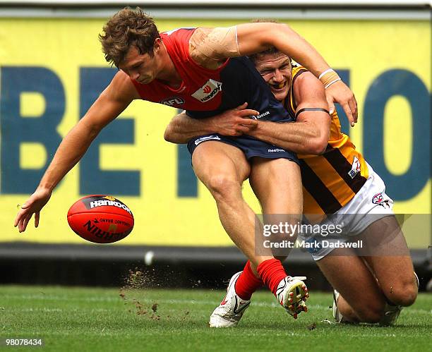 James Strauss of the Demons is tackled by Campbell Brown of the Hawks during the round one AFL match between the Melbourne Demons and the Hawthorn...