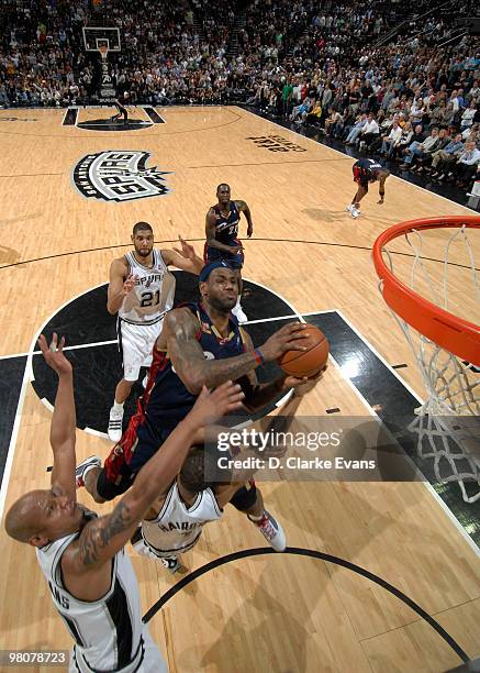 LeBron James of the Cleveland Cavaliers shoots against Malik Hairston and Keith Bogans of the San Antonio Spurs on March 26, 2010 at the AT&T Center...