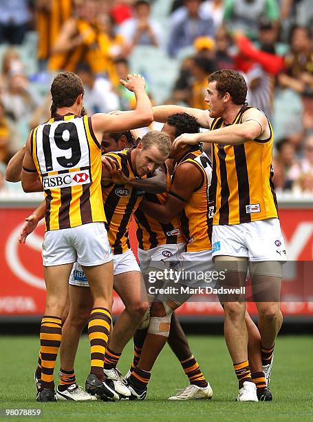 Hawthorn players gather around to celebrate with Carl Peterson of the Hawks after he kicked a goal during the round one AFL match between the...