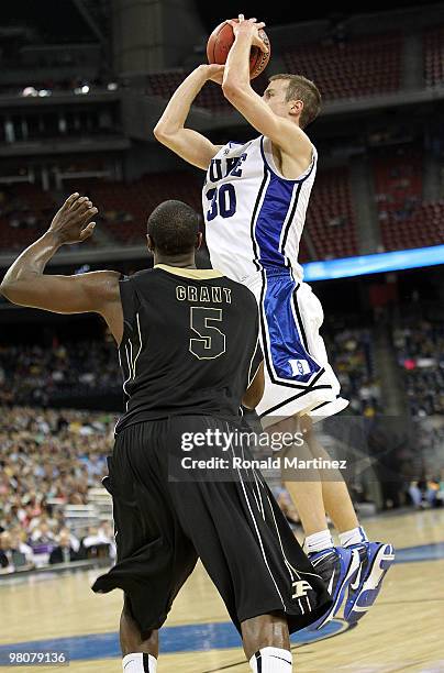 Guard Jon Scheyer of the Duke Blue Devils takes a shot against Keaton Grant of the Purdue Boilermakers during the south regional semifinal of the...