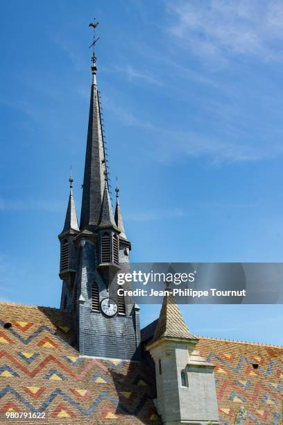 colourful roof and slate tiles clock tower of the village church of ruffey-lès-beaune, église saint-léger, near beaune, bourgogne, france - église stock-fotos und bilder