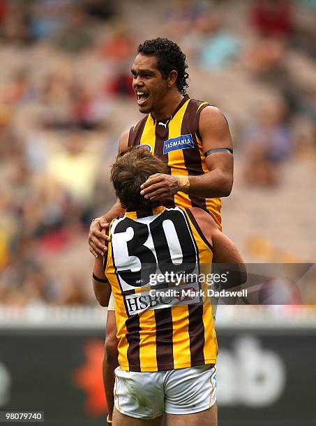 Campbell Brown of the Hawks lifts up Rhan Hooper after he scored a goal during the round one AFL match between the Melbourne Demons and the Hawthorn...