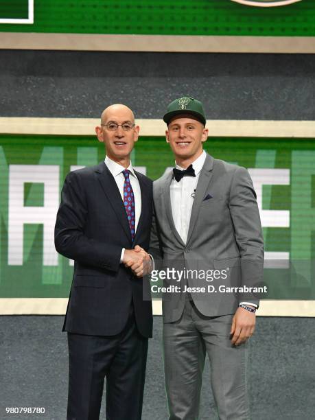 Donte Divincenzo shakes hands with NBA Commissioner Adam Silver after being selected number seventeen overall by the Milwaukee Bucks during the 2018...
