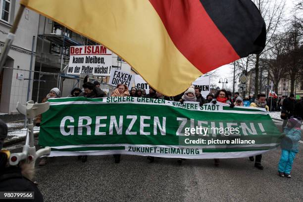 March 2018, Germany, Cottbus: Participants in an anti-refugee demonstration by the group "Zukunft Heimat" carry a banner. Photo: Carsten Koall/dpa