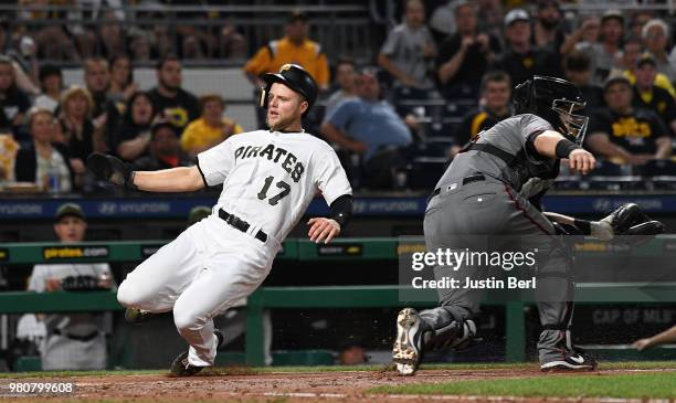 Austin Meadows of the Pittsburgh Pirates slides safely into home plate past Alex Avila of the Arizona Diamondbacks in the sixth inning during the...