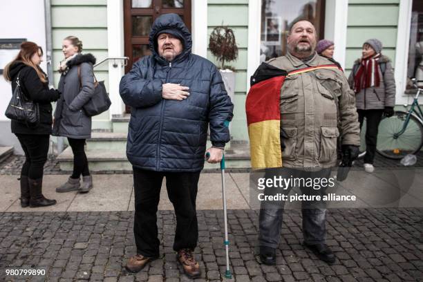 Participants sing the German national anthem as they take part in an anti-refugee demonstration orginized by the group 'Zukunft Heimat', in Cottbus,...