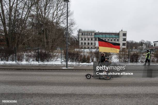 March 2018, Germany, Cottbus: Two participants in an anti-refugee demonstration by the group "Zukunft Heimat" with a German flag. Photo: Carsten...