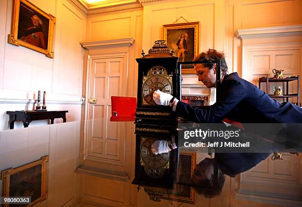 Charlotte Rostek, curator at Dumfries House adjusts a Queen Anne clock for British Summer Time on March 26, 2010 in Cumnock, Scotland. Clocks go...