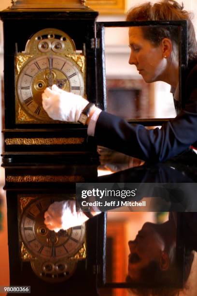 Charlotte Rostek, curator at Dumfries House adjusts a Queen Anne clock for British Summer Time on March 26, 2010 in Cumnock, Scotland. Clocks go...