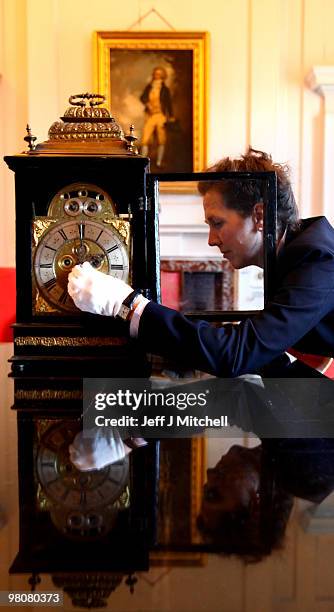 Charlotte Rostek, curator at Dumfries House adjusts a Queen Anne clock for British Summer Time on March 26, 2010 in Cumnock, Scotland. Clocks go...
