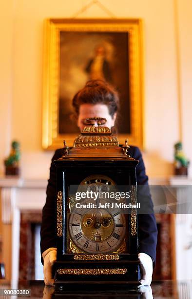 Charlotte Rostek, curator at Dumfries House adjusts a Queen Anne clock for British Summer Time on March 26, 2010 in Cumnock, Scotland. Clocks go...