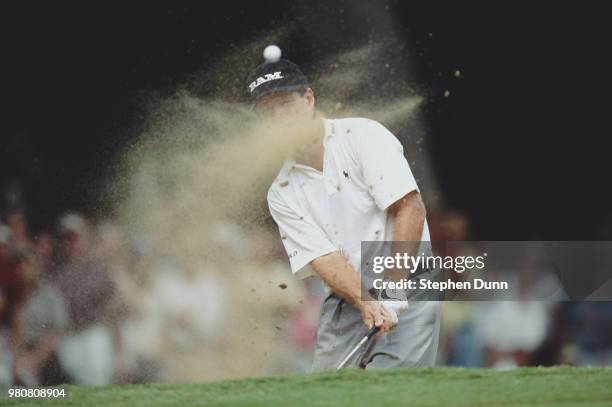 Tom Watson of the United States is partially hidden as he hits out of the sand bunker on his way to winning the PGA MasterCard Colonial golf...