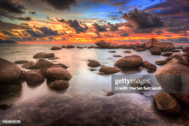 seascape with rocks at sunrise, singkawang, indonesia - singkawang stock pictures, royalty-free photos & images