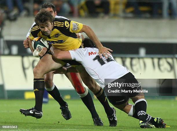 Conrad Smith of the Hurricanes is tackled by Ruan Pienaar and Riaan Swanepoel of the Sharks during the round seven Super 14 match between the...