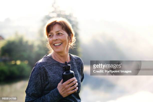 senior woman resting after exercise outdoors in nature in the foggy morning. copy space. - active lifestyle stock-fotos und bilder