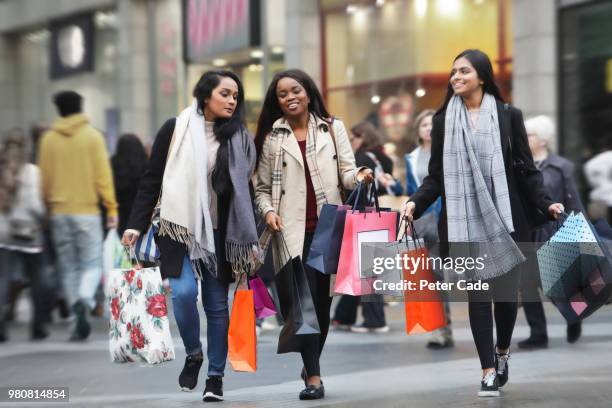 three young women in town shopping - new merchandise stock pictures, royalty-free photos & images