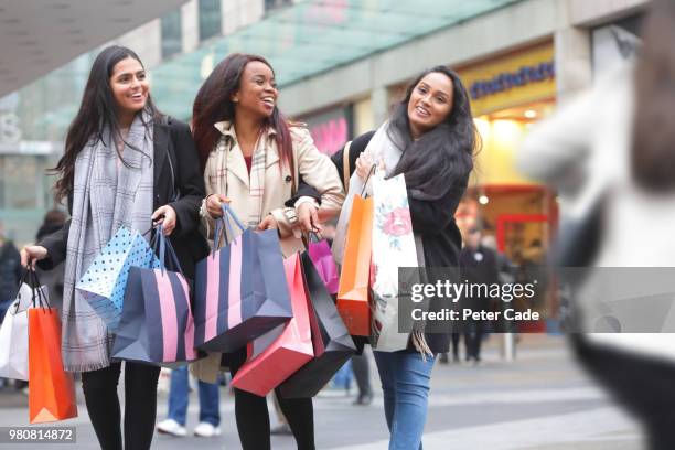 three young women in town shopping - shopping excitement stock pictures, royalty-free photos & images