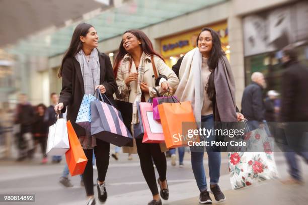 three young women in town shopping - shopping bag 個照片及圖片檔