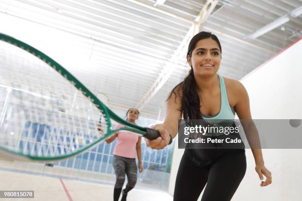 two young woman playing squash - schlägersport stock-fotos und bilder