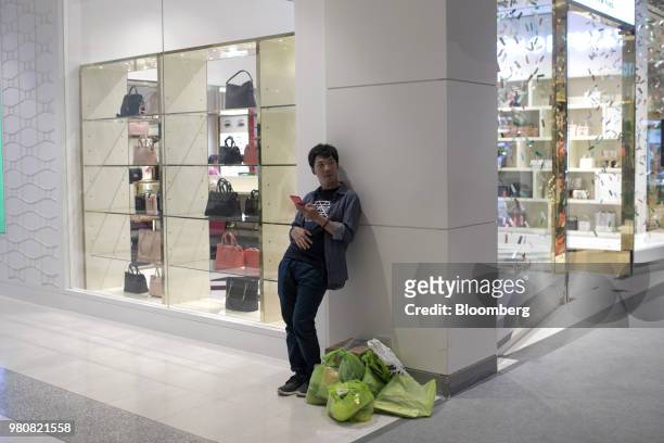 Shopper stands outside a Kate Spade & Co. Store at the CentralWorld shopping mall, operated by Central Pattana Pcl , in Bangkok, Thailand, on...