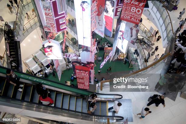 Shoppers ride escalators at the CentralWorld shopping mall, operated by Central Pattana Pcl , in Bangkok, Thailand, on Saturday, June 16, 2018....