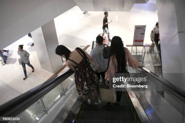 Shoppers ride an escalator at the CentralWorld shopping mall, operated by Central Pattana Pcl , in Bangkok, Thailand, on Saturday, June 16, 2018....
