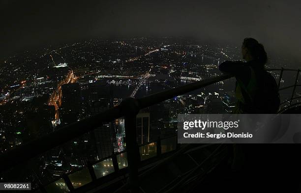 Woman looks over Sydney's skyline from Sydney Tower after lights are switched off for Earth Hour on March 27, 2010 in Sydney, Australia. Earth hour...