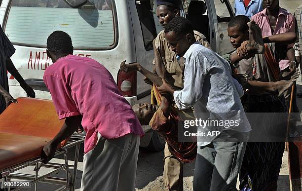 Somali police officers and medical assistants at Madina hospital carry a soldier who was injured in a roadside bomb attack in Mogadishu on March 27,...