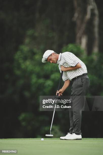 Jesper Parnevik of Sweden playing with the upturned bill on his hat anchors his full length broomhandle putter during the Doral-Ryder Open golf...