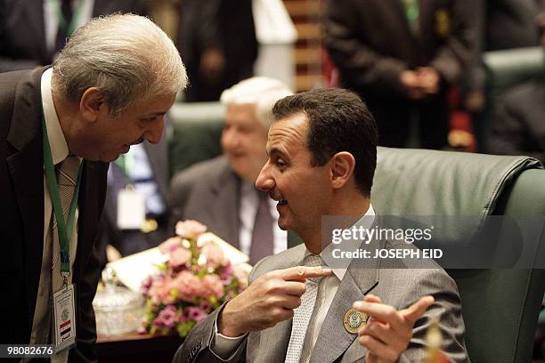 Syrian President Bashar al-Assad talks to a member of his delegation at the opening of the Arab Summit on March 27, 2010 the Libyan city of Sirte....